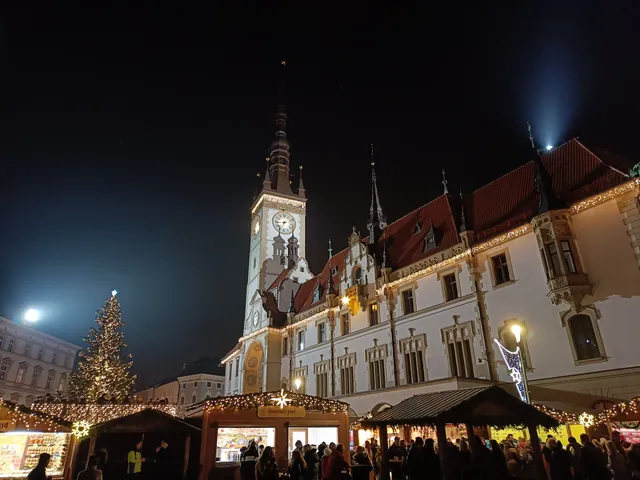 Rathaus mit Turm, Weihnachtsbaum und eine Reihe beleuchteter Stände auf dem Oberring