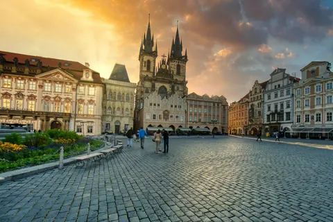 Spaziergänger auf dem Altstädter Ring vor der Teynkirche bei Sonnenuntergang